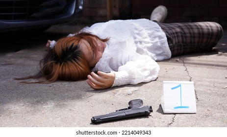 Woman Died By Car Cracshed Her. Femaile Pedestrian Lies Down As Passed Away On Road By Silver Car As Road Accident. Female Body Death From Murder On Road Trip From Murderer's Short Gun.