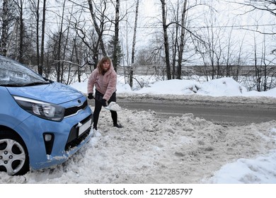 Woman Digging A Car Stuck In The Snow