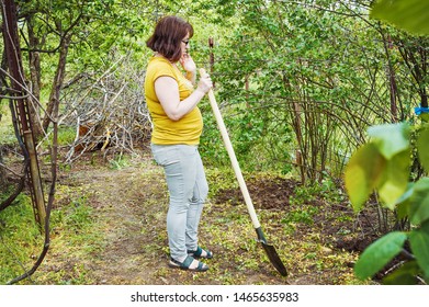 Woman Digging With A Shovel In The Garden