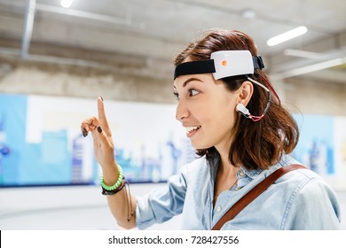 Woman with digital headset sensor connected to her ear, reading brain impulses
