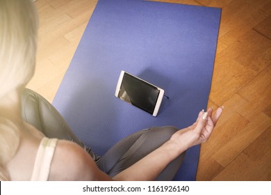 Woman With Digital Tablet Using Meditation App In Bedroom .