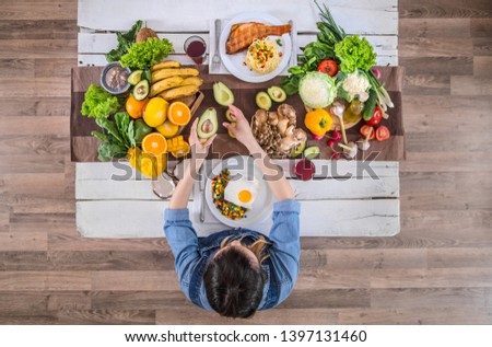 Woman at the dining table with a variety of organic healthy food , top view. The concept of healthy eating and celebration