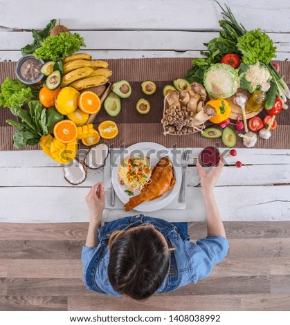 Woman at the dining table with a variety of organic healthy food , top view. The concept of healthy eating and celebration