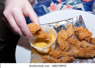 Woman Dipping A Chicken Tender In Honey Mustard Sauce