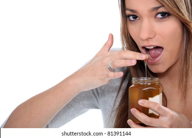 Woman Dipping Finger In Honey Jar