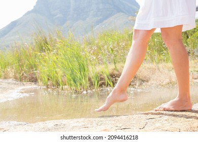 Woman Dipping Toe In Rural Pond