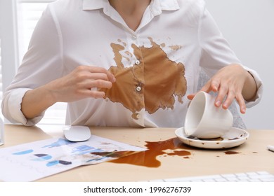 Woman In Dirty Shirt At Wooden Desk With Coffee Spill, Closeup