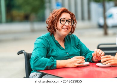 Woman with disability using electric wheelchair drinking coffee with friend sitting in an outdoor cafeteria in the city - Powered by Shutterstock