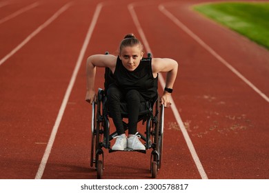 A woman with disablity driving a wheelchair on a track while preparing for the Paralympic Games - Powered by Shutterstock