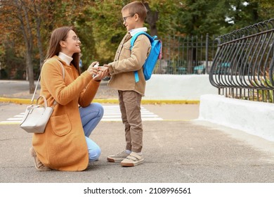 Woman disinfecting hands of her little son before school - Powered by Shutterstock