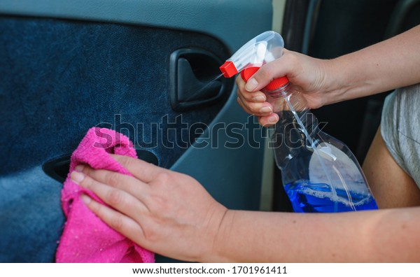 A woman is disinfecting her car\
with a pink wipe. Prevent the virus and bacterias, Prevent covid19,\
corona virus, Alcohol Sanitizer. Hygiene concept at\
home.