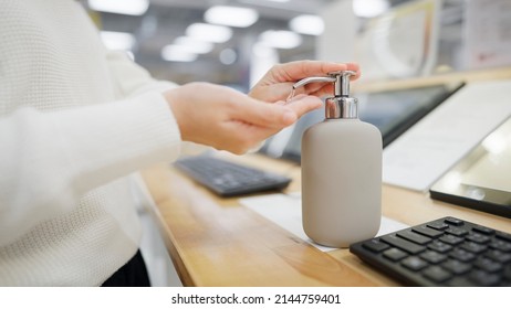 Woman Disinfecting Her Hands With Alcohol Gel On In Department Store, COVID-19, New Normal Retail Shop.