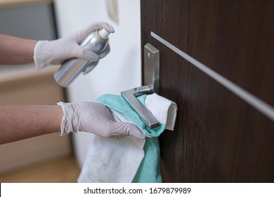 The Woman Disinfects The Door Handle With A Disinfectant Liquid.