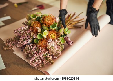 Woman In Disposable Nitrile Gloves Wrapping A Mixed Flower Bouquet