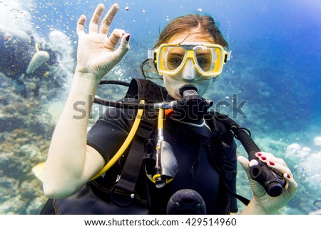 Woman diving in her vacation on coral reef giving the ok sign