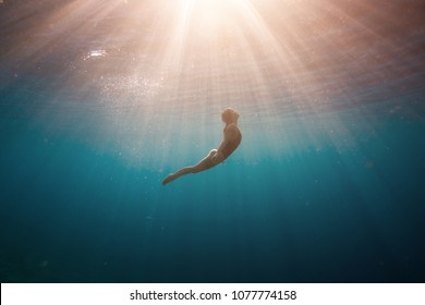 Woman Diving Into The Blue Ocean