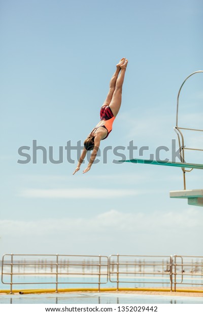 春の板からプールに飛び込む女性 水泳プールに逆さまに飛び込む女性 の写真素材 今すぐ編集