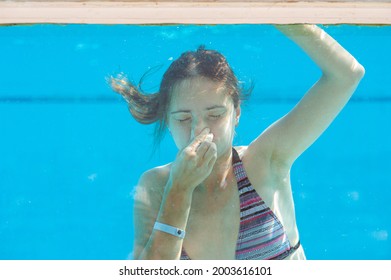 Woman Is Diving In The Pool And Holding Her Nose 