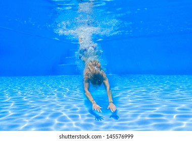 Woman Diving Underwater In The Swimming Pool