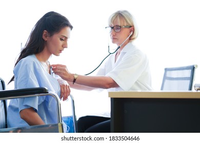 Woman Doctor Check The Pressure Of Women Patient's.The Female Doctor Smiled And Made Eye Contact With The Patient. Doctor Using Sphygmomanometer With Stethoscope Checking Blood Pressure To A Patient