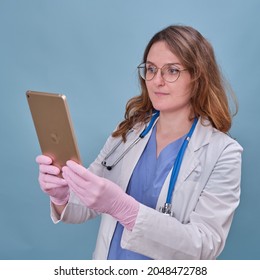 Woman Doctor With A Digital Tablet Apple IPad In A White Uniform On A Blue Studio Background - Moscow, Russia, September 16, 2021