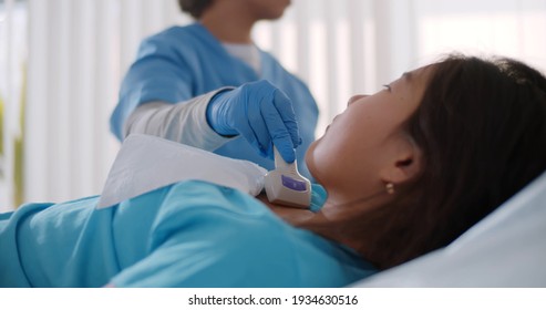 Woman Doctor Examining Patient Child Girl Thyroid Gland Using Ultrasound Scanner Machine. Close Up Of Medical Specialist Doing Sonogram Of Asian Kid Chest