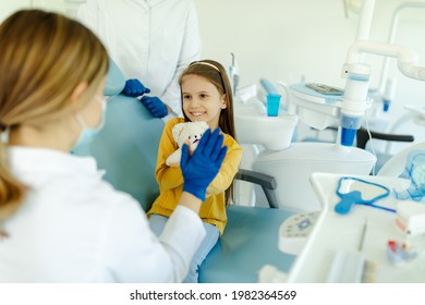 Woman Doctor Is Giving Hi Five To Little Girl After A Successful Dental Examination.