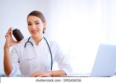 Woman Doctor Holding Package With Pills. Hospital Worker With Vitamins