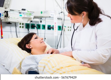 Woman Doctor At Intensive Care Unit Of Clinic Checking Her Patient With Stethoscope