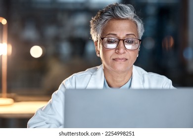 Woman, doctor and laptop in office at night at workplace, hospital or desk for medical career vision. Healthcare expert, dark clinic or focus for reading at computer, email or cancer research article