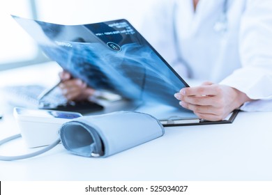 Woman Doctor Looking at X-Ray Radiography in patient's Room