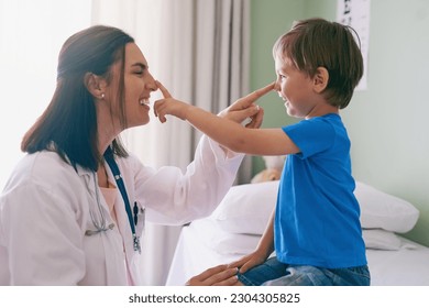 Woman doctor, playing and child at a hospital for healthcare and medical consultation. Fun, nose poke and pediatrician working with a laugh and happiness in a clinic with boy patient with exam - Powered by Shutterstock