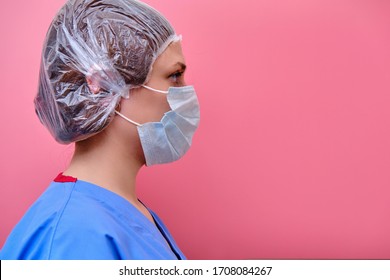 Woman Doctor Portrait In Profile Close-up, Copy Space For Text. Girl Nurse In A Medical Mask On A Red Background, The Concept Of Resistance To The Coronavirus Epidemic