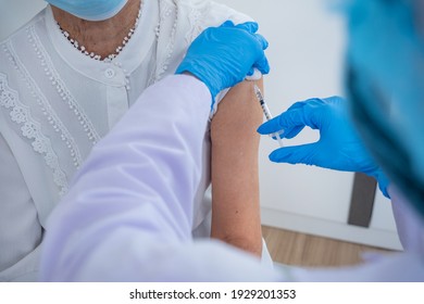 Woman Doctor Is Preparing A Vaccine For An Older Asian Woman Wearing White Shirts To Build The Coronavirus Or COVID-19 Immune System.