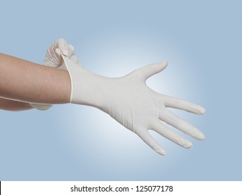 Woman doctor pulling on white surgical gloves.