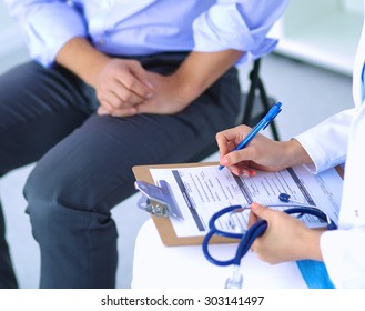 Woman Doctor Talking To Her Male Patient At Office