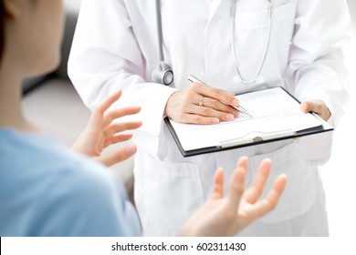 Woman Doctor Talking To Her Male Patient At Office