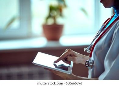 Woman Doctor Using Tablet Computer In Hospital