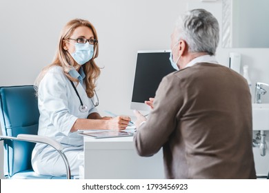 Woman doctor wear protection face mask talking with patient in clinic office