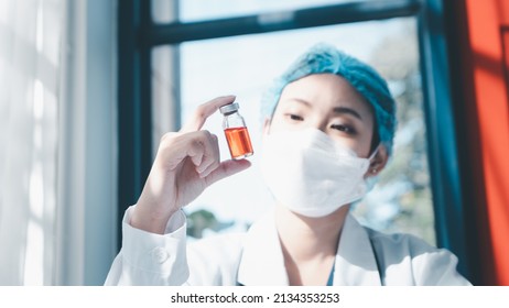 Woman Doctor Wearing A Face Shield And PPE Suit For Coronavirus Outbreak Holding Showing Covid-19 Vaccine At Laboratory Room, Concept Of Covid-19 Quarantine. Healthcare Concept In Hospital. 