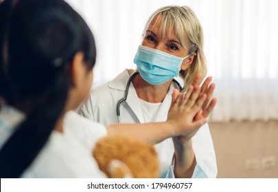 Woman Doctor Wearing Protective Mask Service Help Support Discussing And Consulting Talk To Little Girl Patient And Giving Hi Five Check Up Information In Hospital