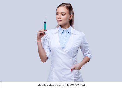 Woman doctor wearing uniform holding syringe on isolated background, young nurse, hospital staff - Powered by Shutterstock