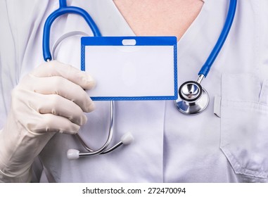 Woman Doctor In A White Coat Holding A Blank Badge