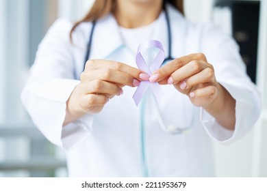 Woman doctor white uniform hold purple ribbon on hand symbol of Pancreatic cancer awareness - Shutterstock ID 2211953679