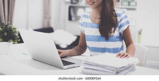 Woman With Documents Sitting On The Desk And Laptop