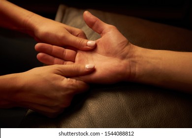 A woman does acupressure fingers for a man. hand massage with intimate lighting. Prelude before making love. Close. Complete relaxation.