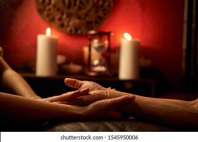 A woman does acupressure fingers for a man. hand massage with intimate lighting. Prelude before making love. Close. Complete relaxation.