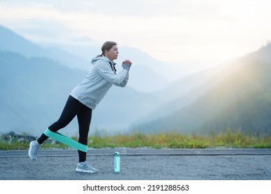 A woman does exercises in the mountains. The concept of a healthy lifestyle. Woman exercising - Shutterstock ID 2191288563