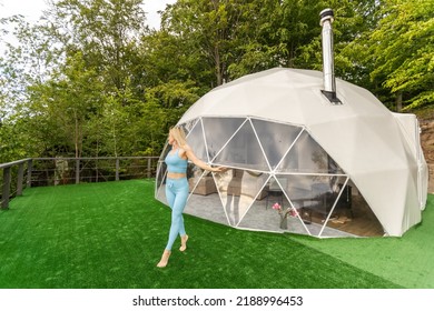 A Woman Does Yoga On The Terrace In A Geo Dome Glamping Tent.