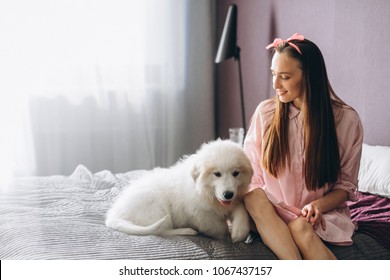 Woman with dog in bed - Shutterstock ID 1067437157